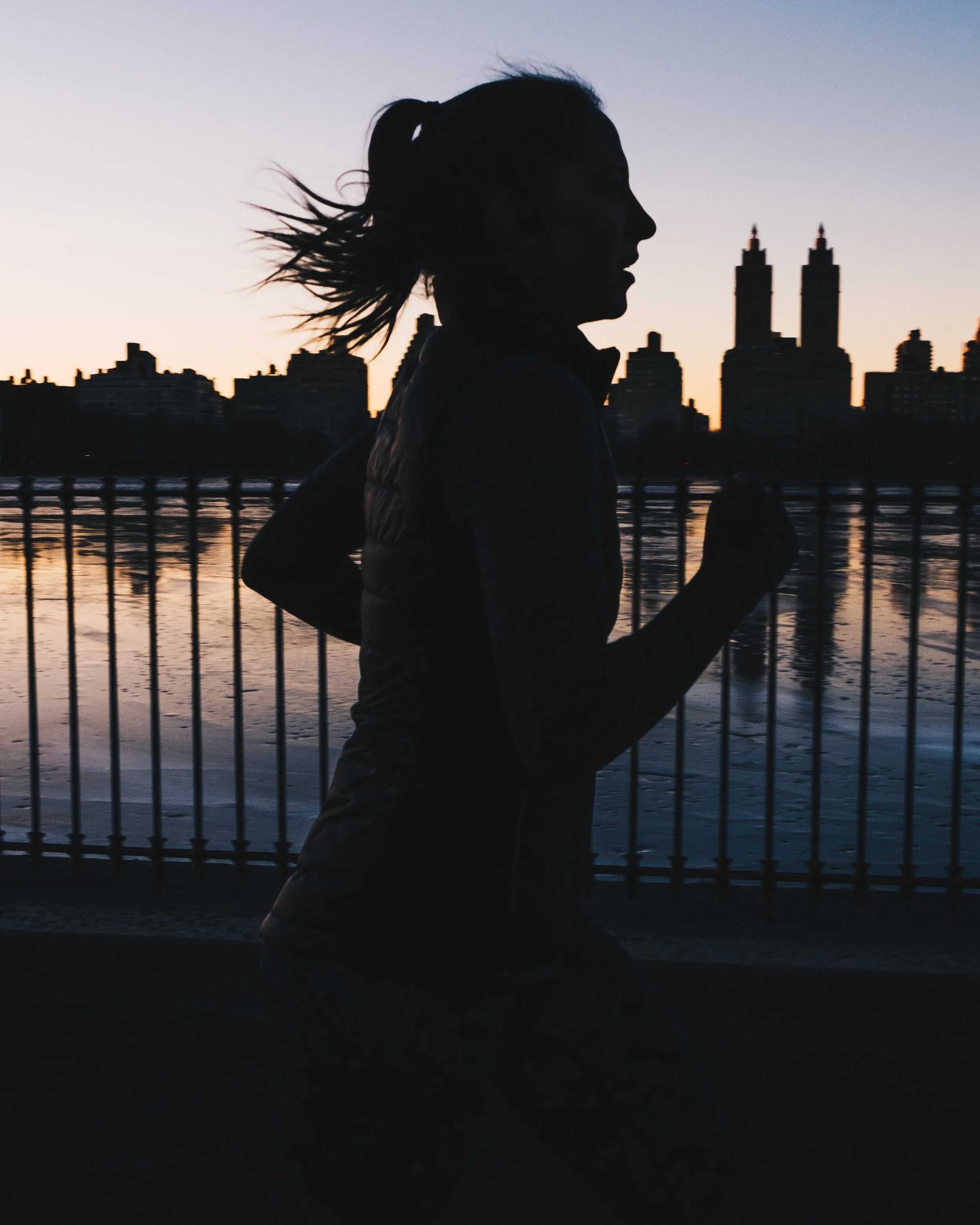 Runner silhouetted against NYC skyline