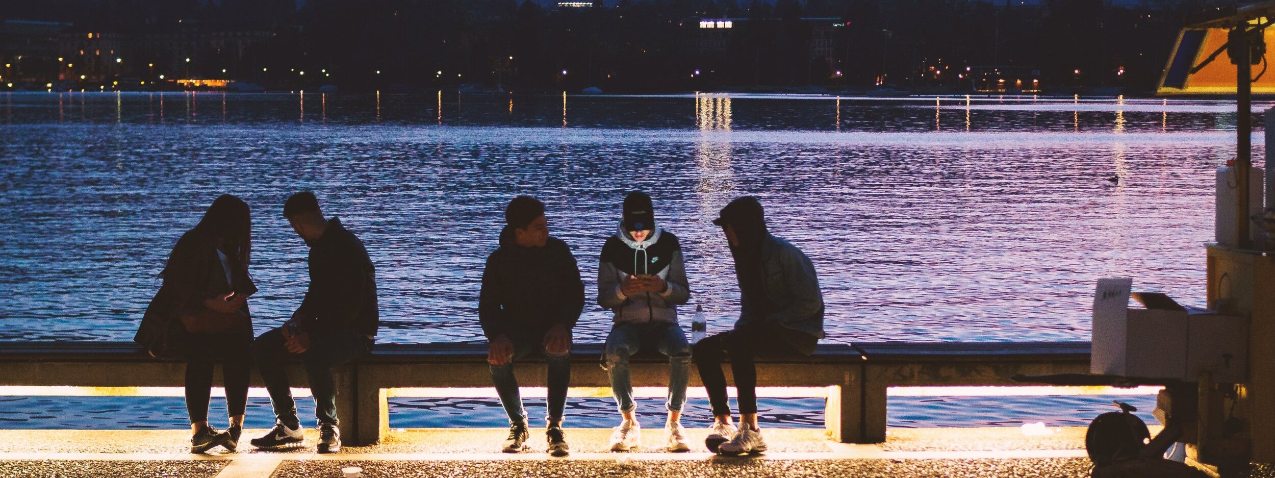 Young people by waterfront at night